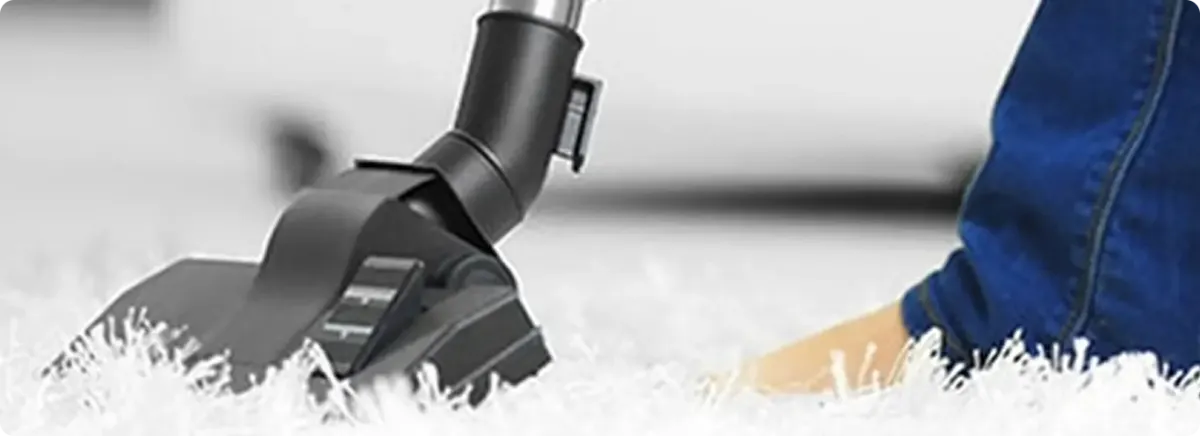 Close-up of a professional vacuuming a white carpet in Chula Vista.